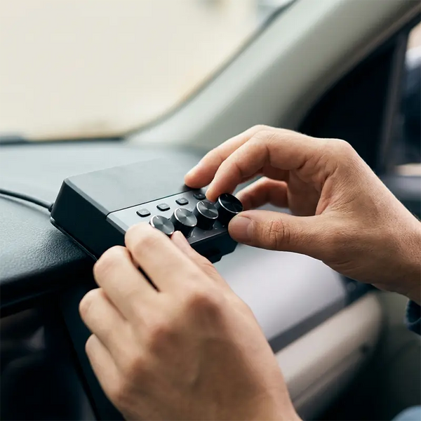 Hände stellen Drehregler an einem DSP-Steuergerät im Auto ein, Feintuning nach dem Einbau
