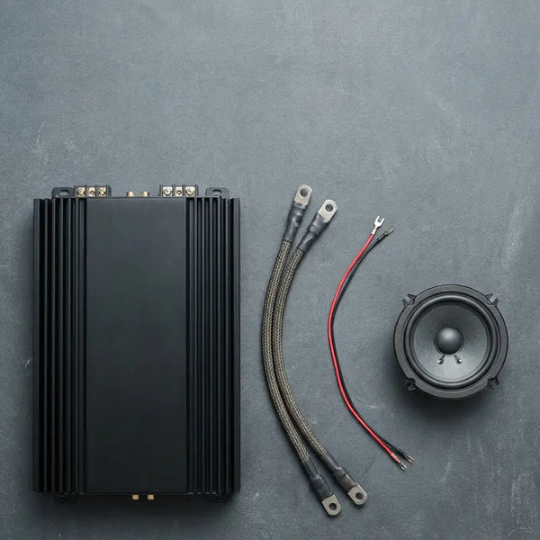 Endstufe, Kabel und kleiner Lautsprecher lose nebeneinander, nicht aufeinander abgestimmtes Setup